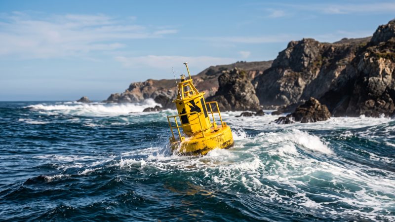 A wave energy converter riding an ocean swell off the California coast in daylight